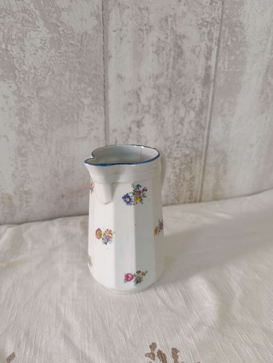 Earthenware milk jug with small flower patterns.