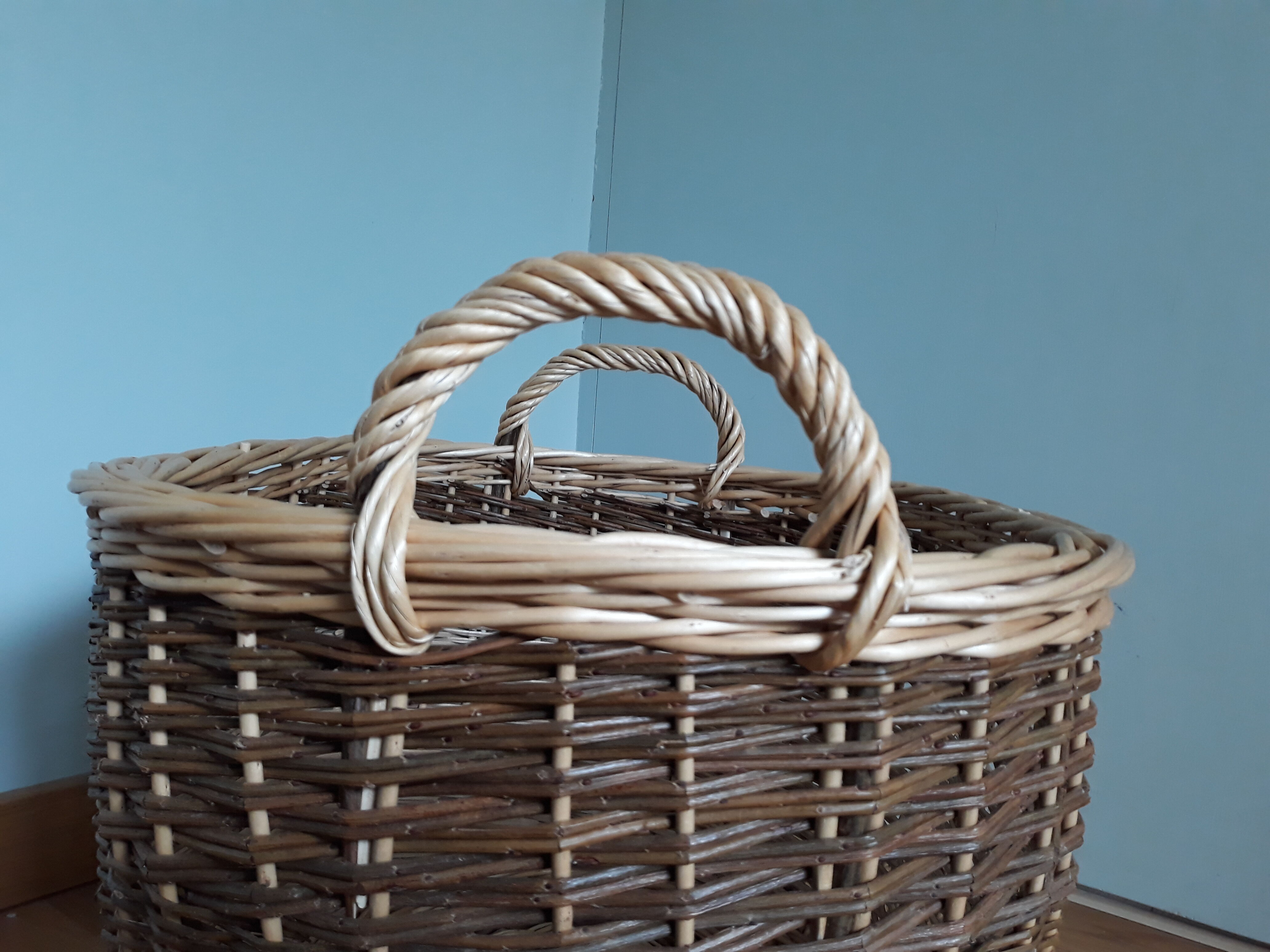 Very large oval laundry basket in two-tone braided wicker with handles