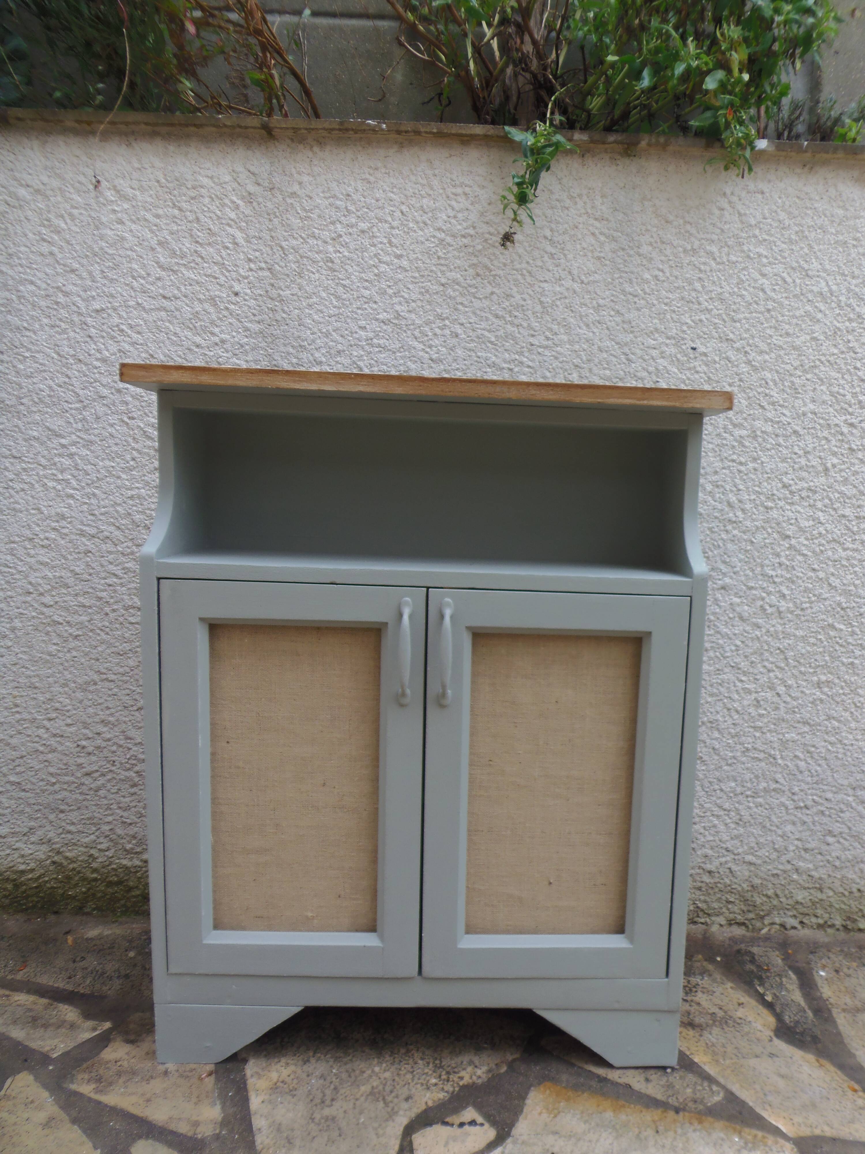 Small vintage green-grey piece of furniture, with 2 doors covered in burlap.