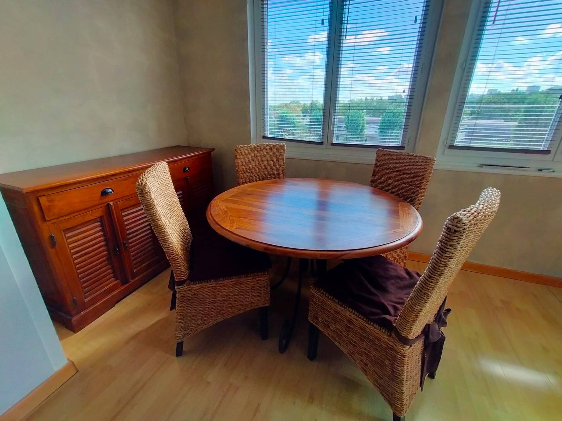 Round wooden table with wrought iron legs.