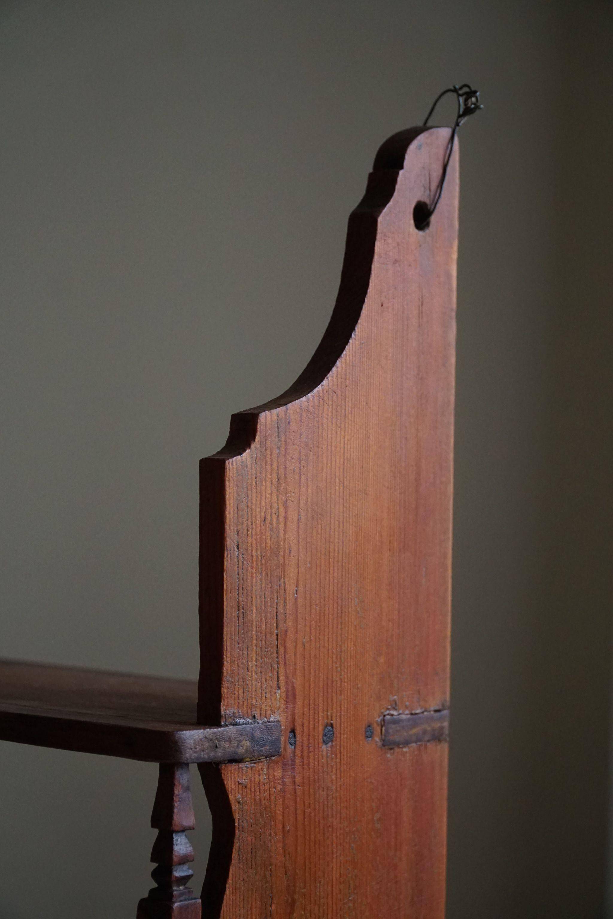 Primitive wall shelf in pine, by a Swedish upholsterer, late 19th century.