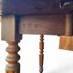 Antique drop-leaf table in wood, with turned legs and castors.