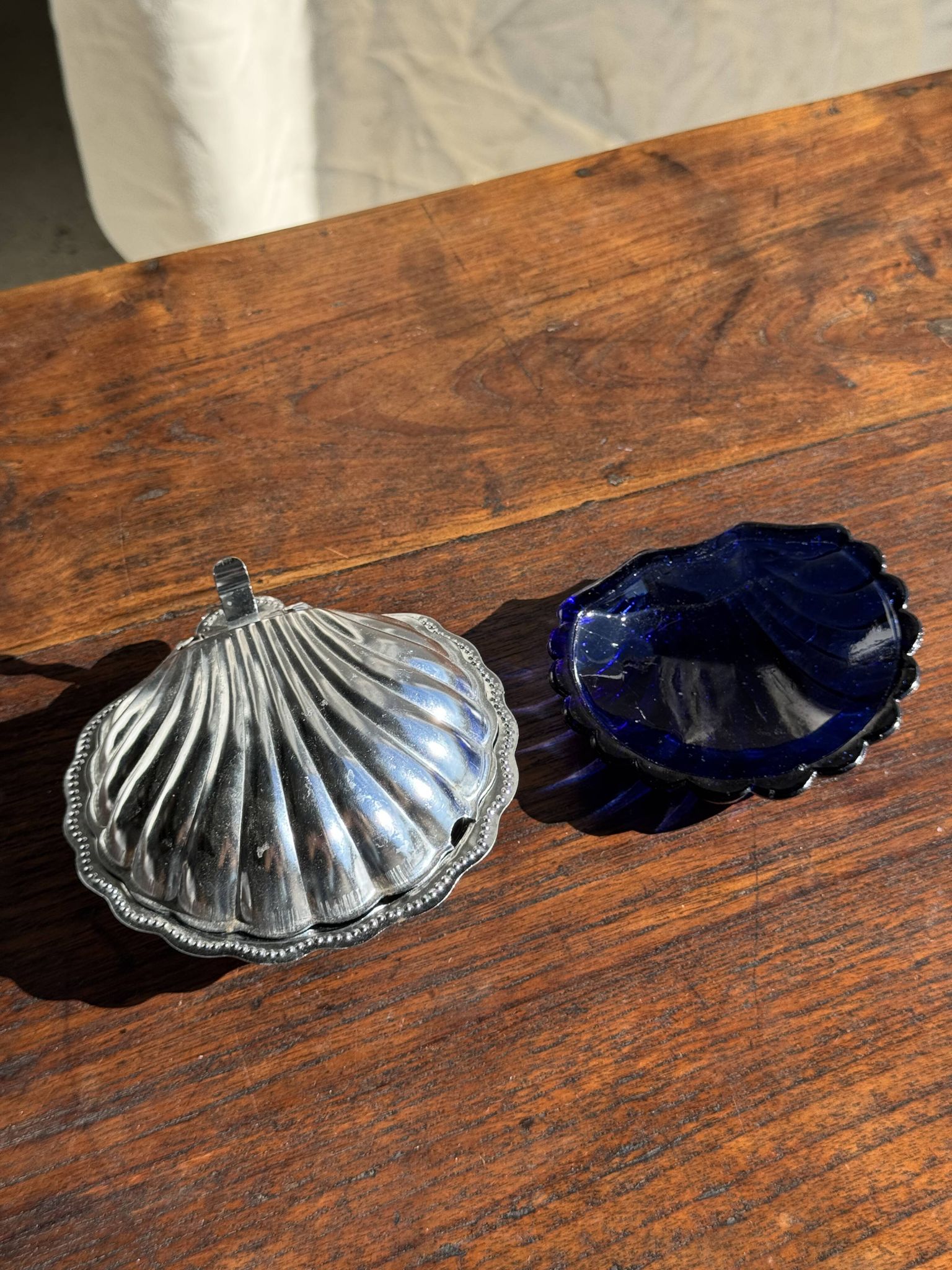 Vintage silver-plated shell butter dish with blue bowl.