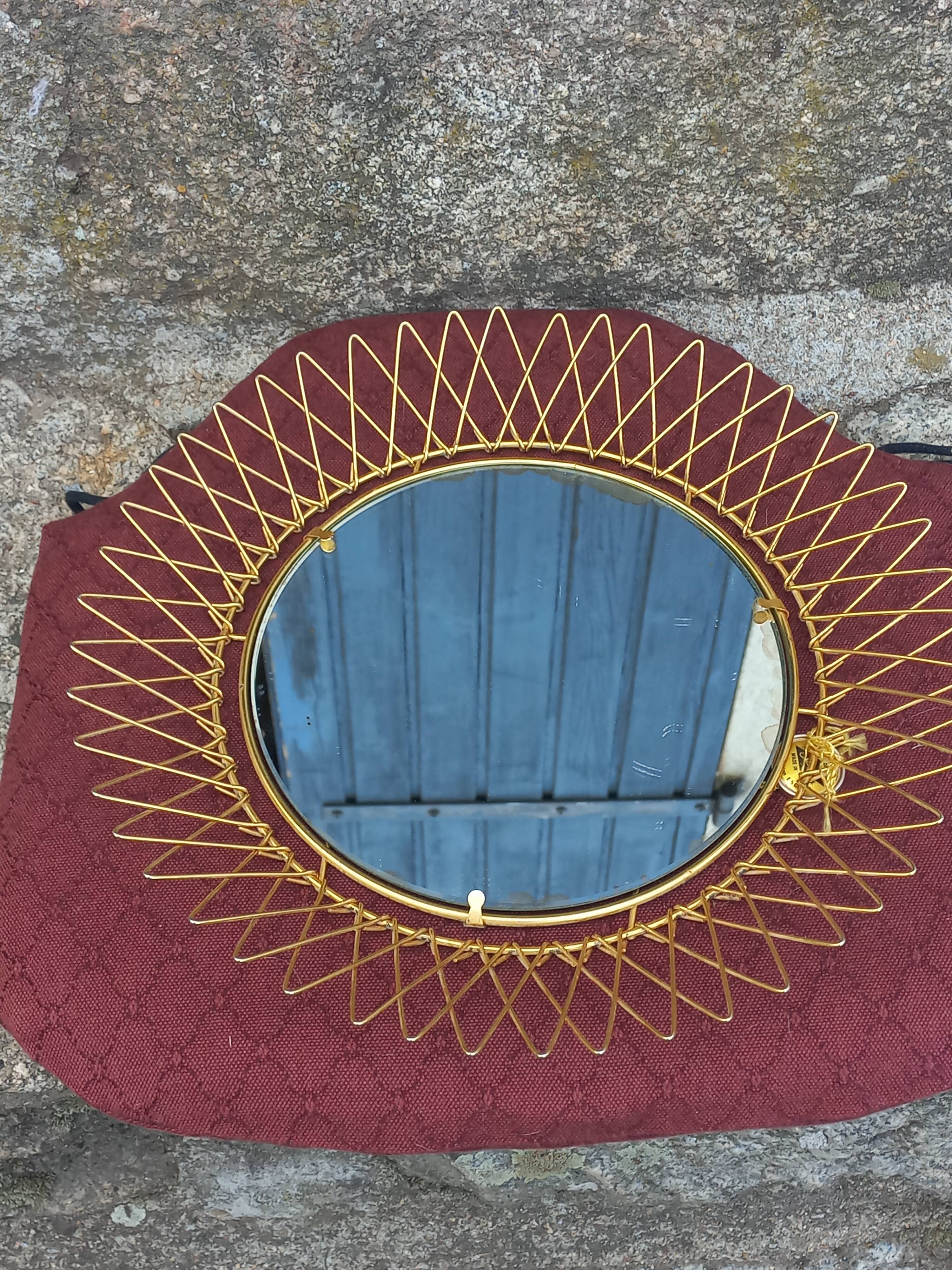Vintage 1950s sun mirror in gold metal.