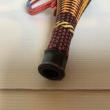 Old bottle in yellow, red and black scoubidou