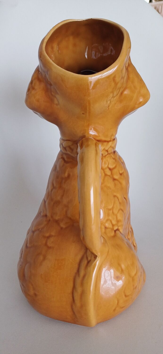 Ancient ceramic pitcher in the shape of a poodle.