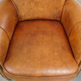 Comfortable, cozy armchair made of sheepskin leather with a neat finish and decorative nailhead trim