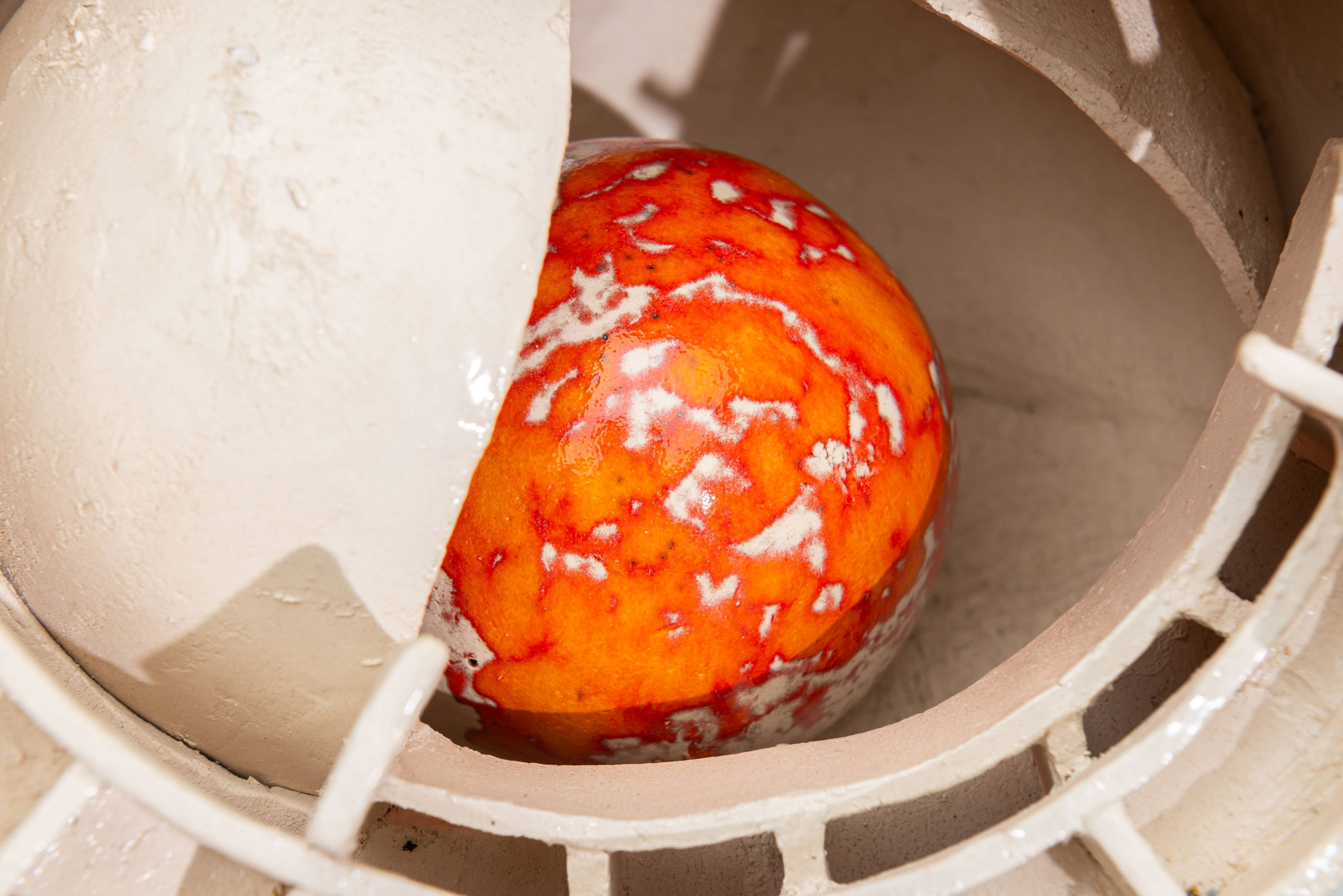 Sculpture en céramique abstraite avec un noyau orange.