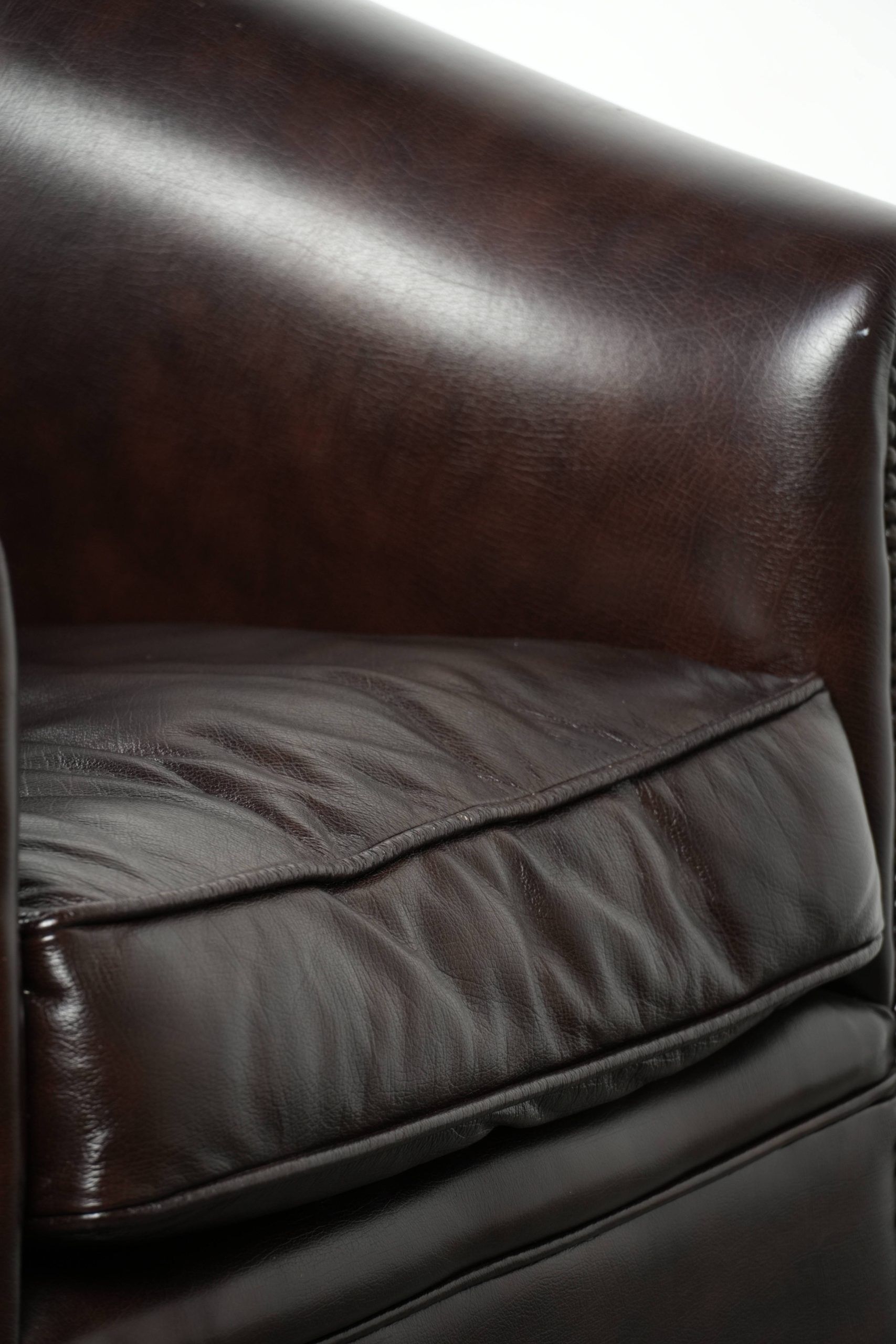 Dark cow leather club armchair with a stylish design in English style