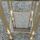 Pair of Hollywood Regency side tables in gold metal and smoked glass.