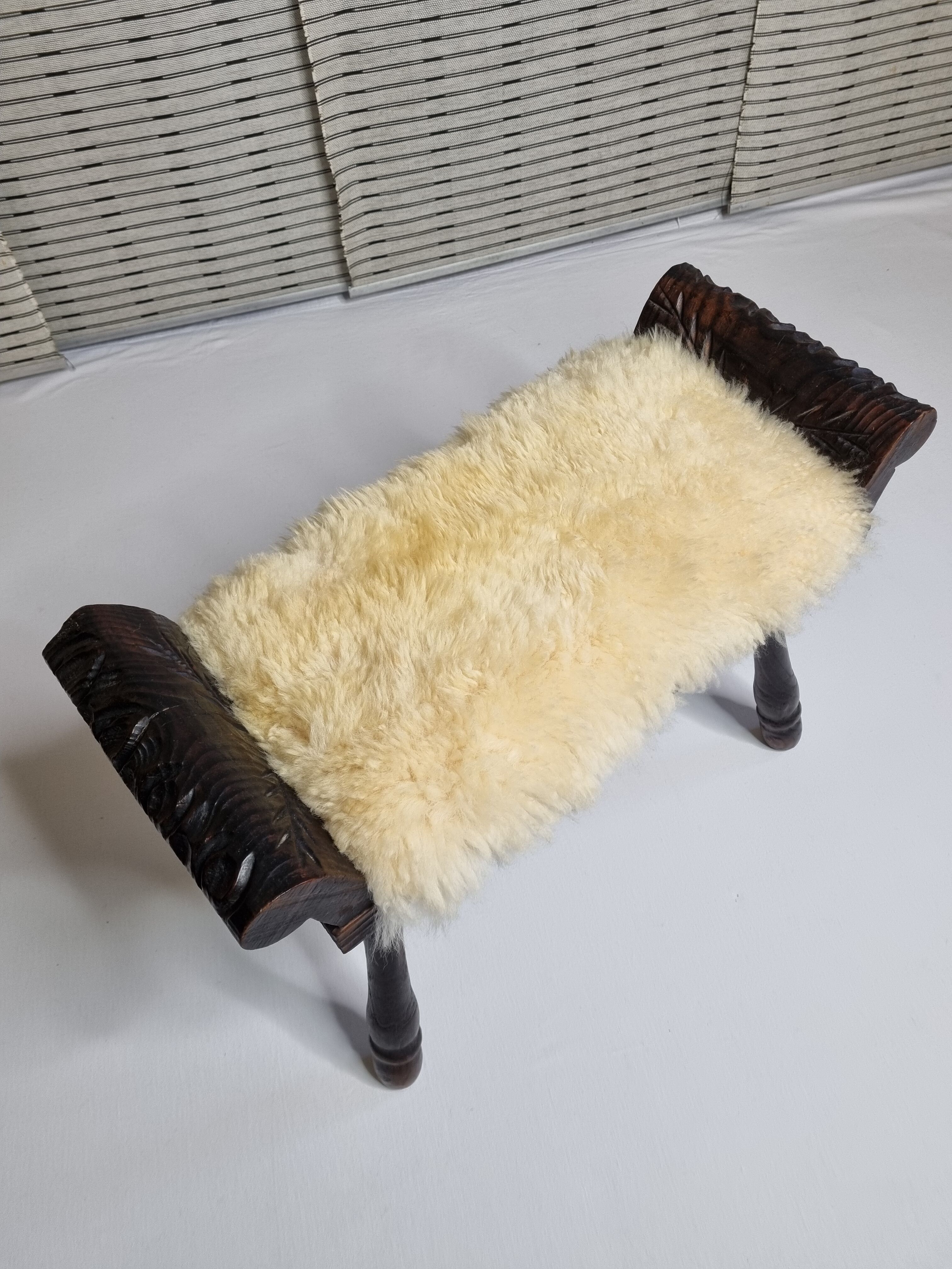 Carved wooden stool covered with Celtic-style sheepskin