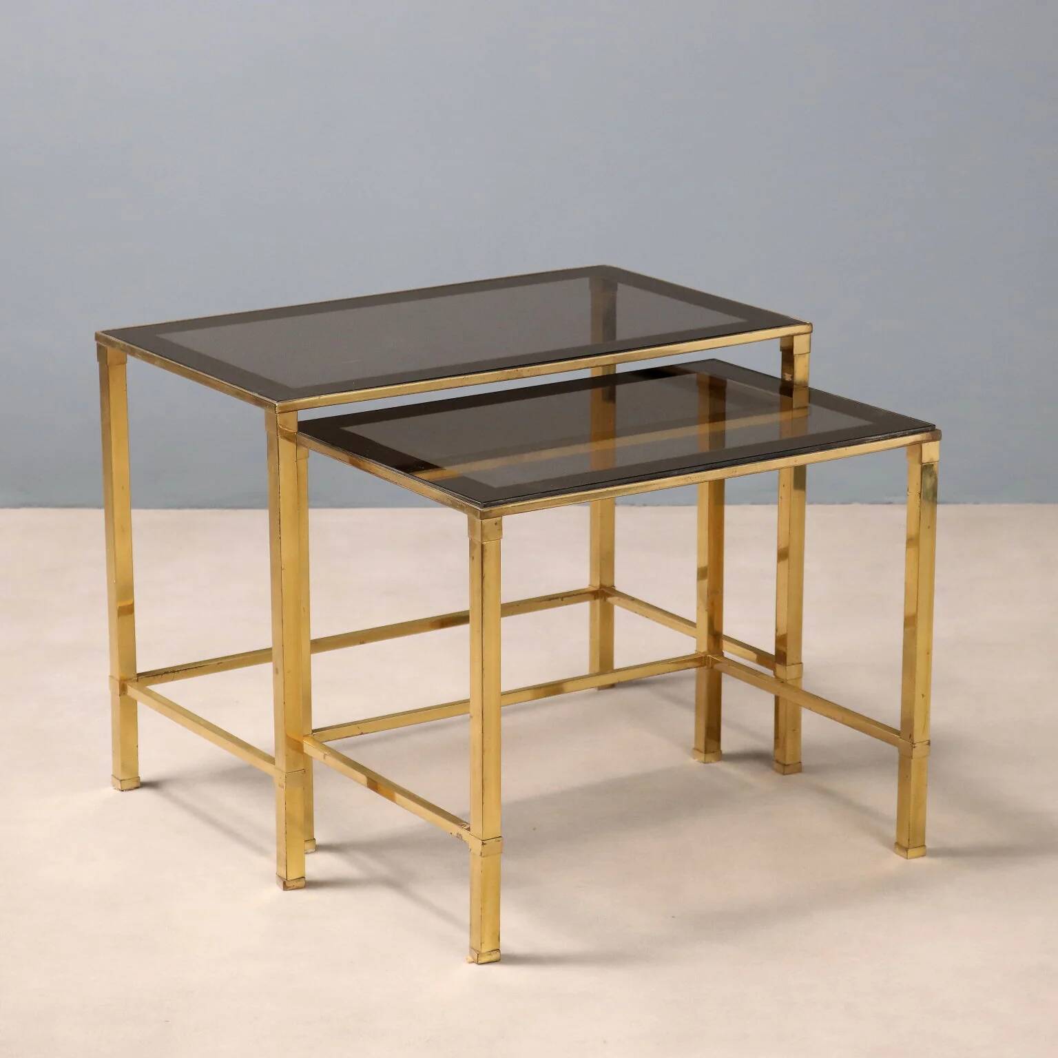 Nested tables in brass and smoked glass.