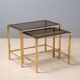 Nested tables in brass and smoked glass.