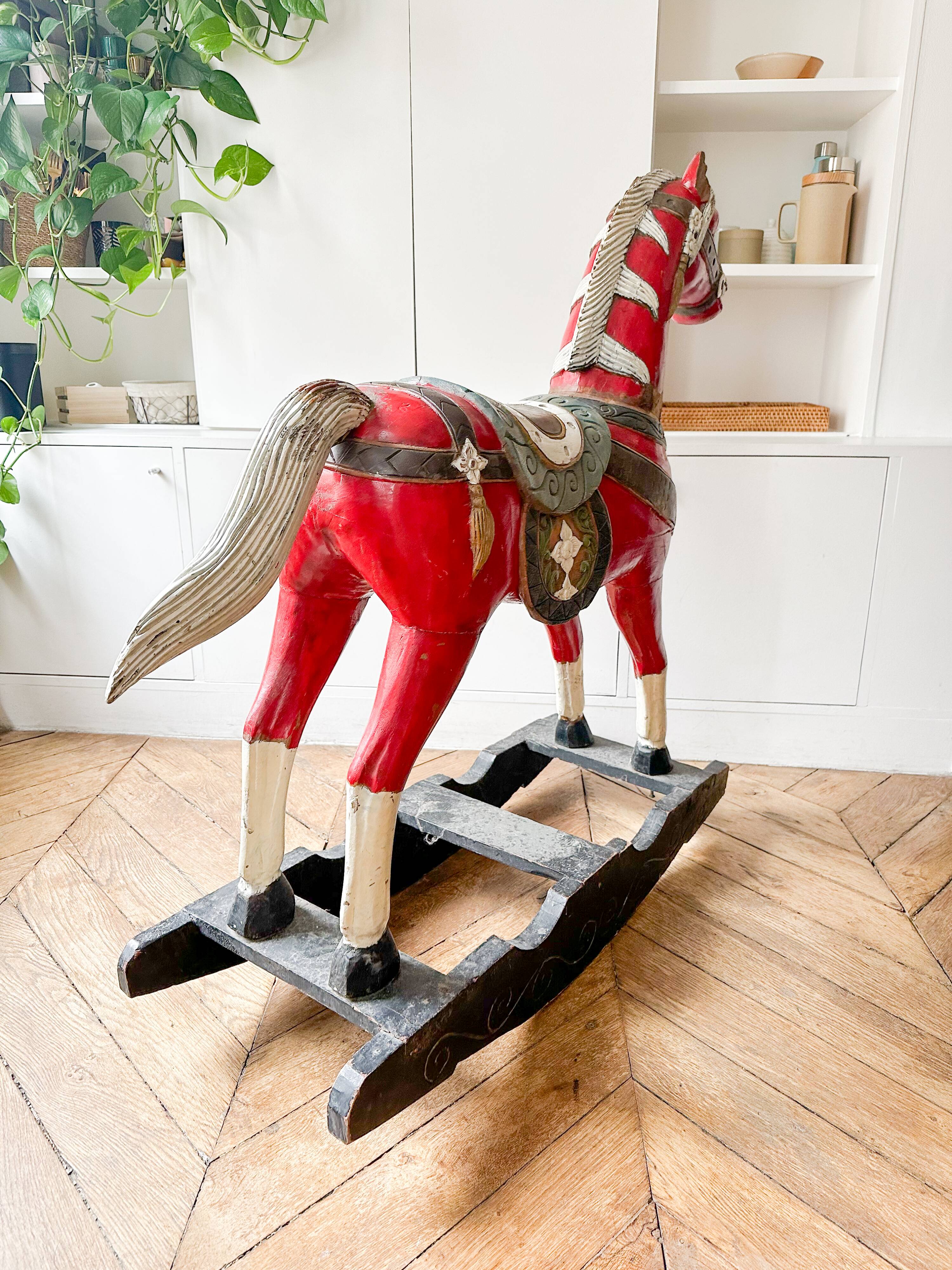Large decorative rocking horse made of carved and hand-painted wood.