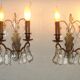 Pair of French antique brass double wall lights with assorted crystals.