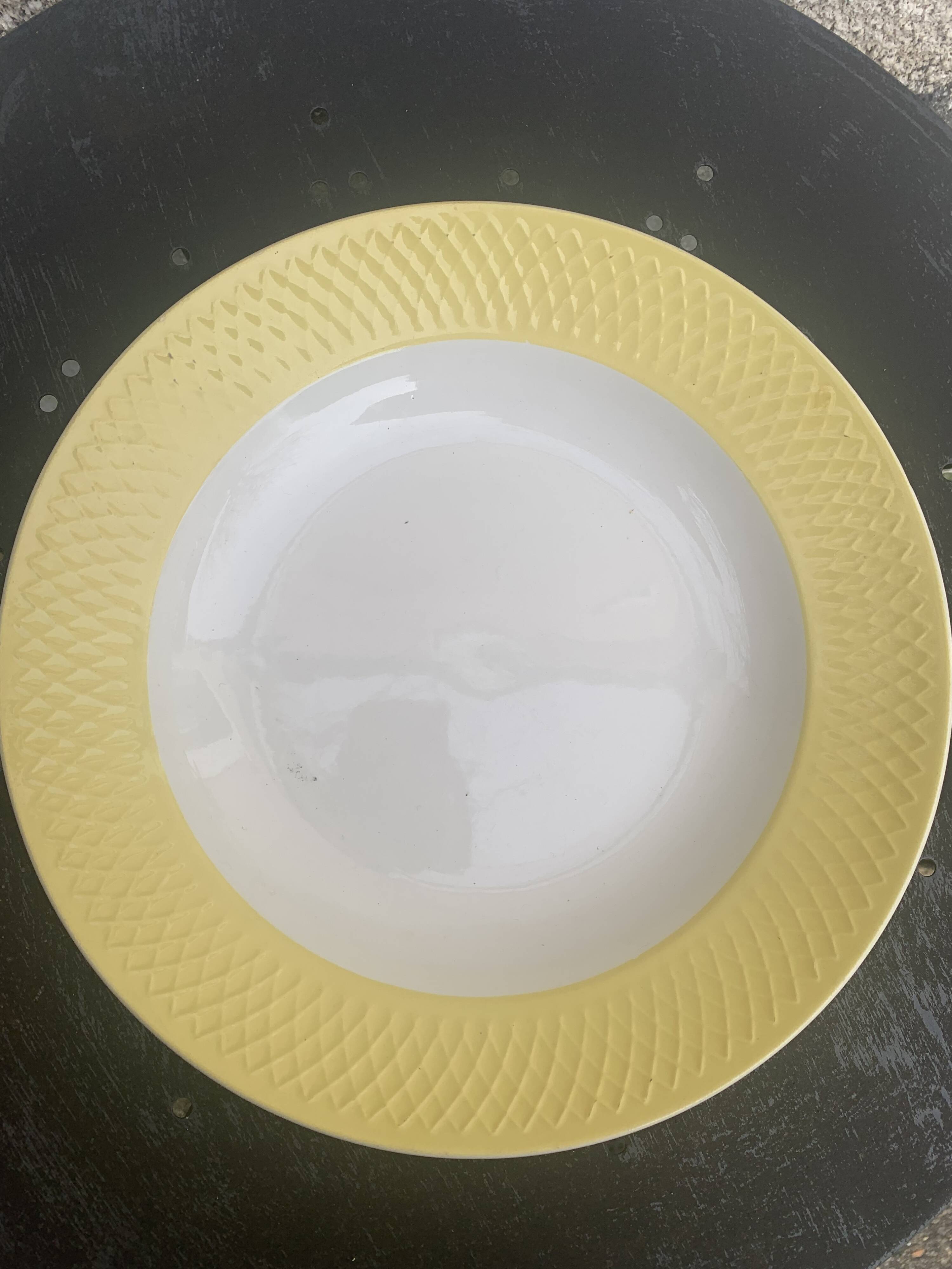 Two earthenware dishes, one hollow and one white cake dish with yellow border
