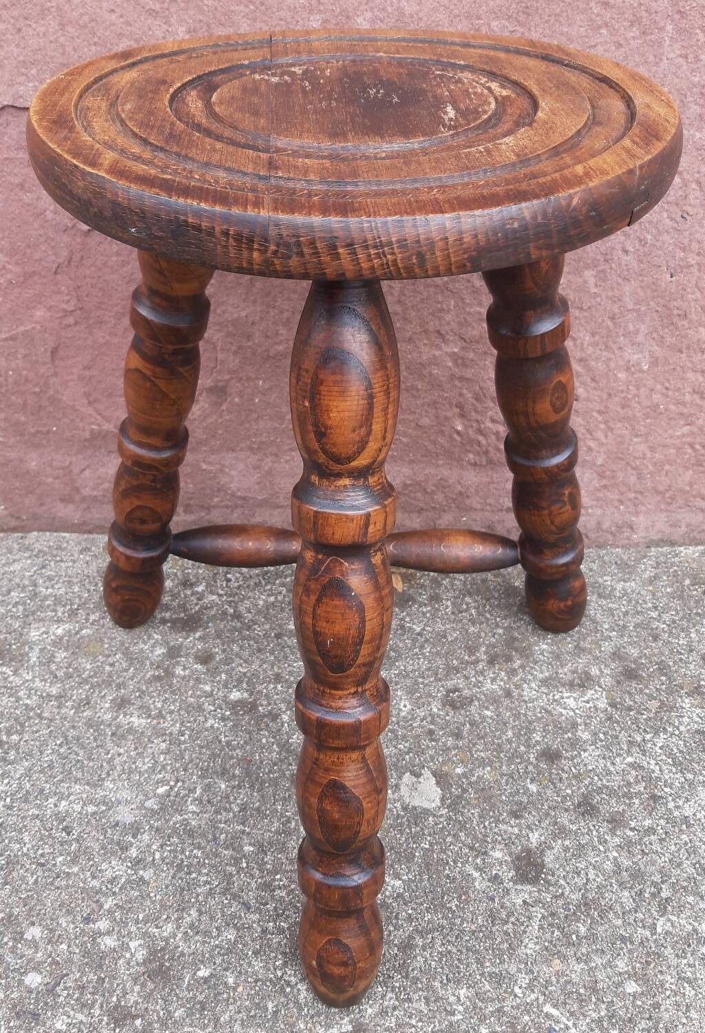 Low wooden tripod stool.