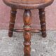 Low wooden tripod stool.