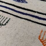 White carpet with multicolored Berber patterns woven hands