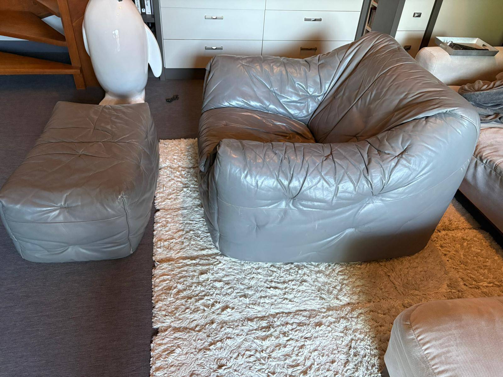Sloop armchair and pouf from Ligne Roset in grey leather.