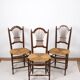 3 wooden and straw chairs, decorated with a sheaf of wheat.