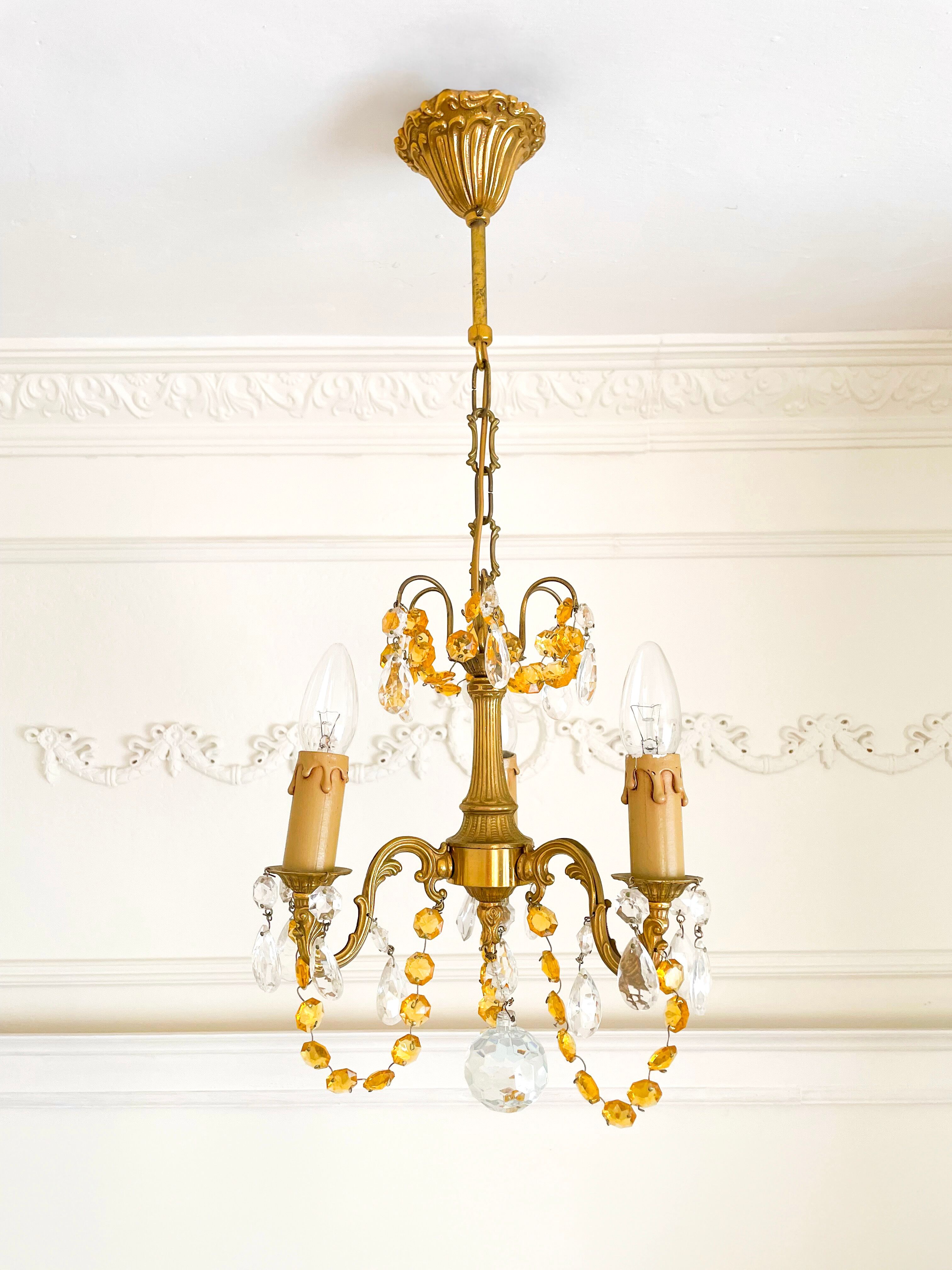 Small vintage brass chandelier with amber crystal pendants.