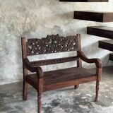 Small antique Indonesian bench in carved teak with plant and floral motifs.