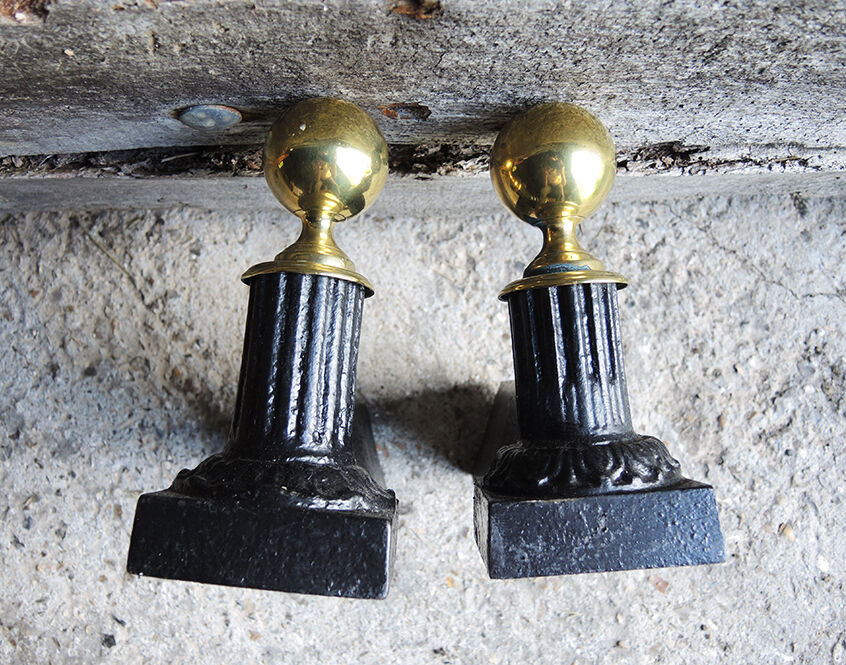 Old cast iron and brass andirons in neoclassical style