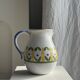 Large white terracotta carafe with a stylized green and yellow frieze pattern