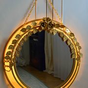 Vintage round illuminated mirror in gold metal with rose decoration.