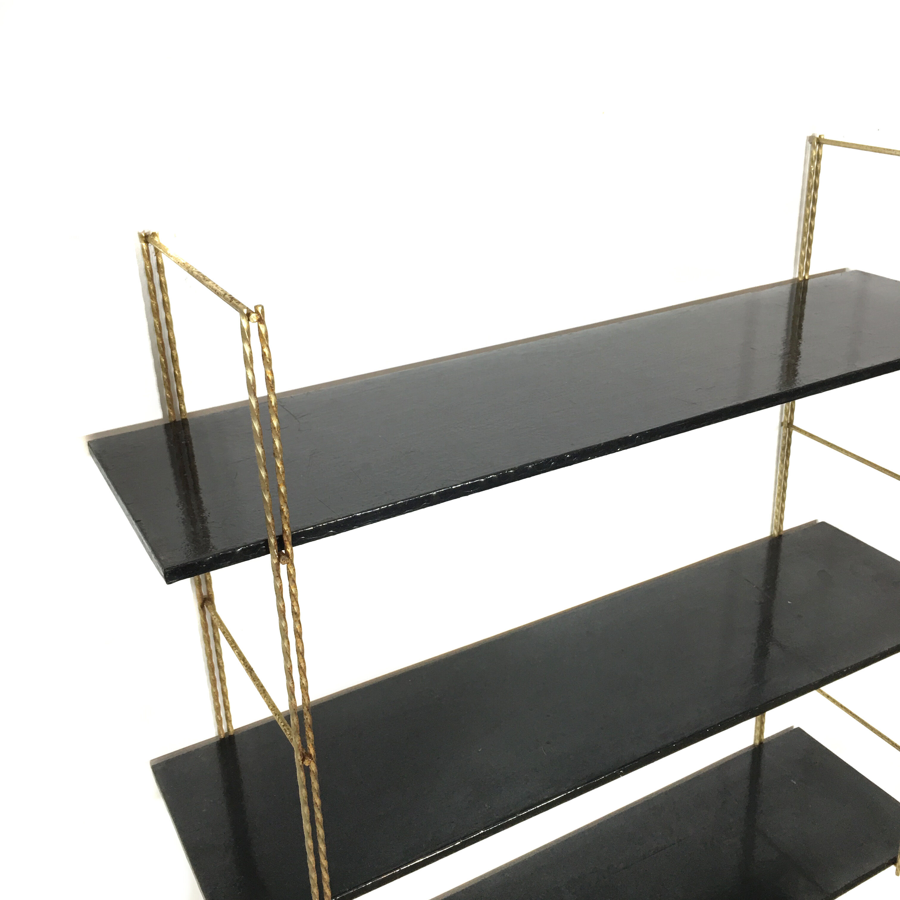 String gold metal shelf and black wood