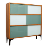 A vintage mid-century 3 tiered bookcase with glass sliding doors