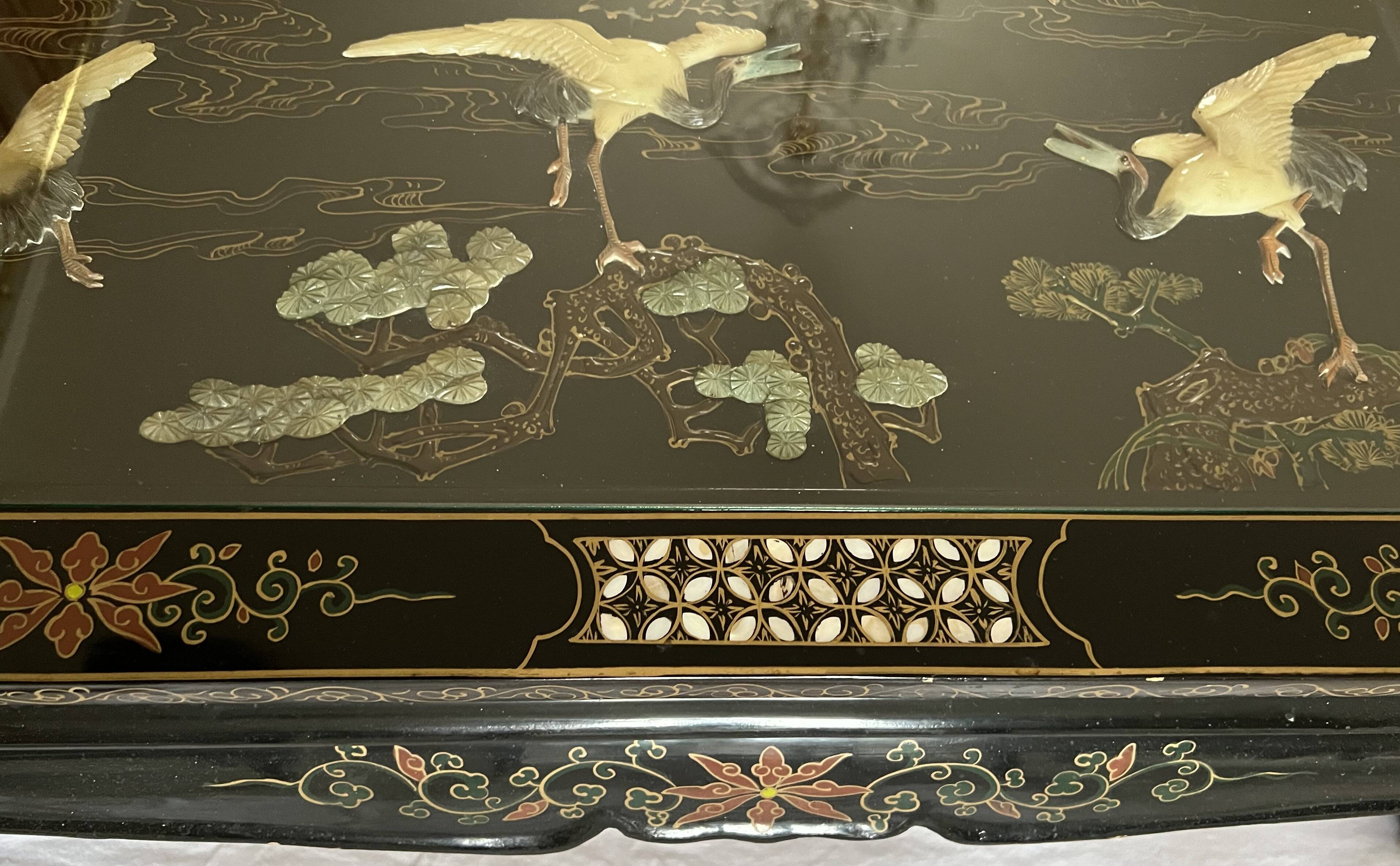 Chinese black wood table inlaid with mother-of-pearl featuring a relief scene of a crane.