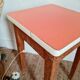 Wooden wax stool and orange formica