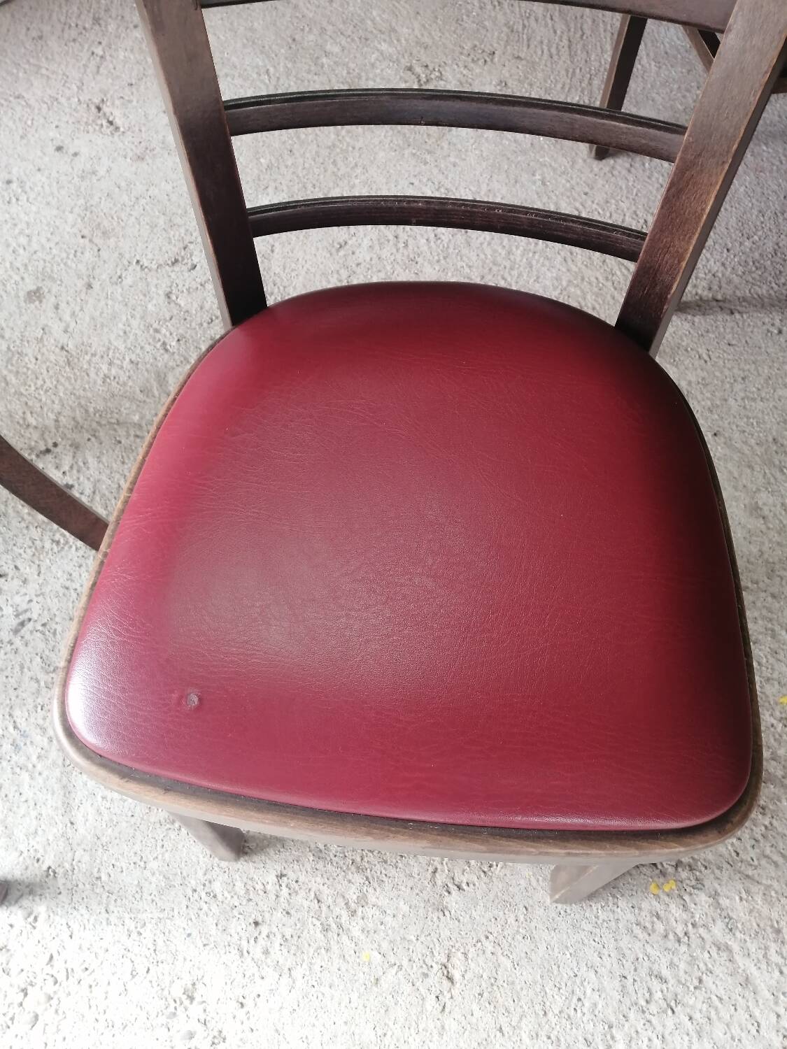 Set of 19 vintage wooden bistro chairs with red faux leather.
