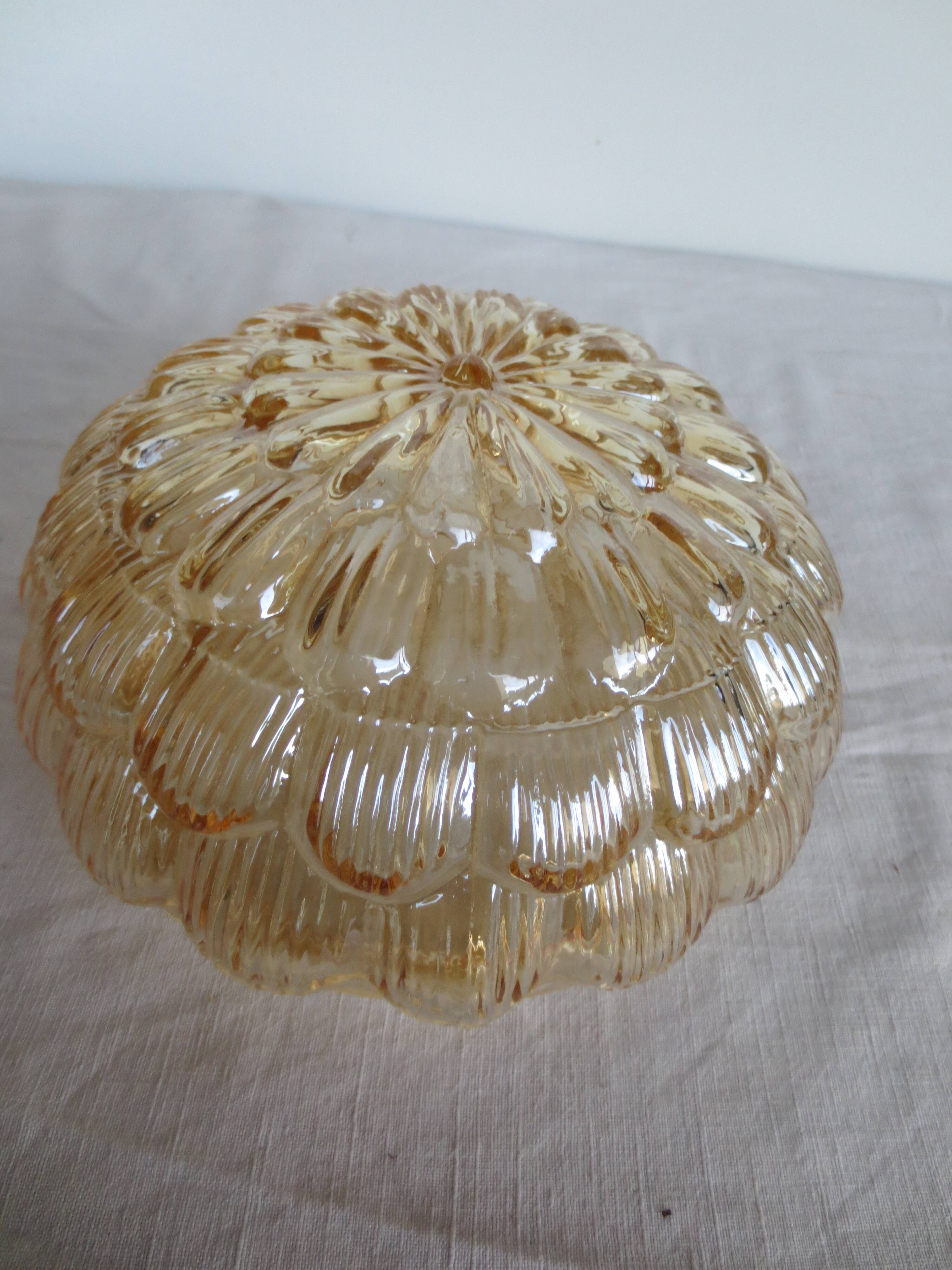 ceiling light with amber glass globe, on a round light wood base