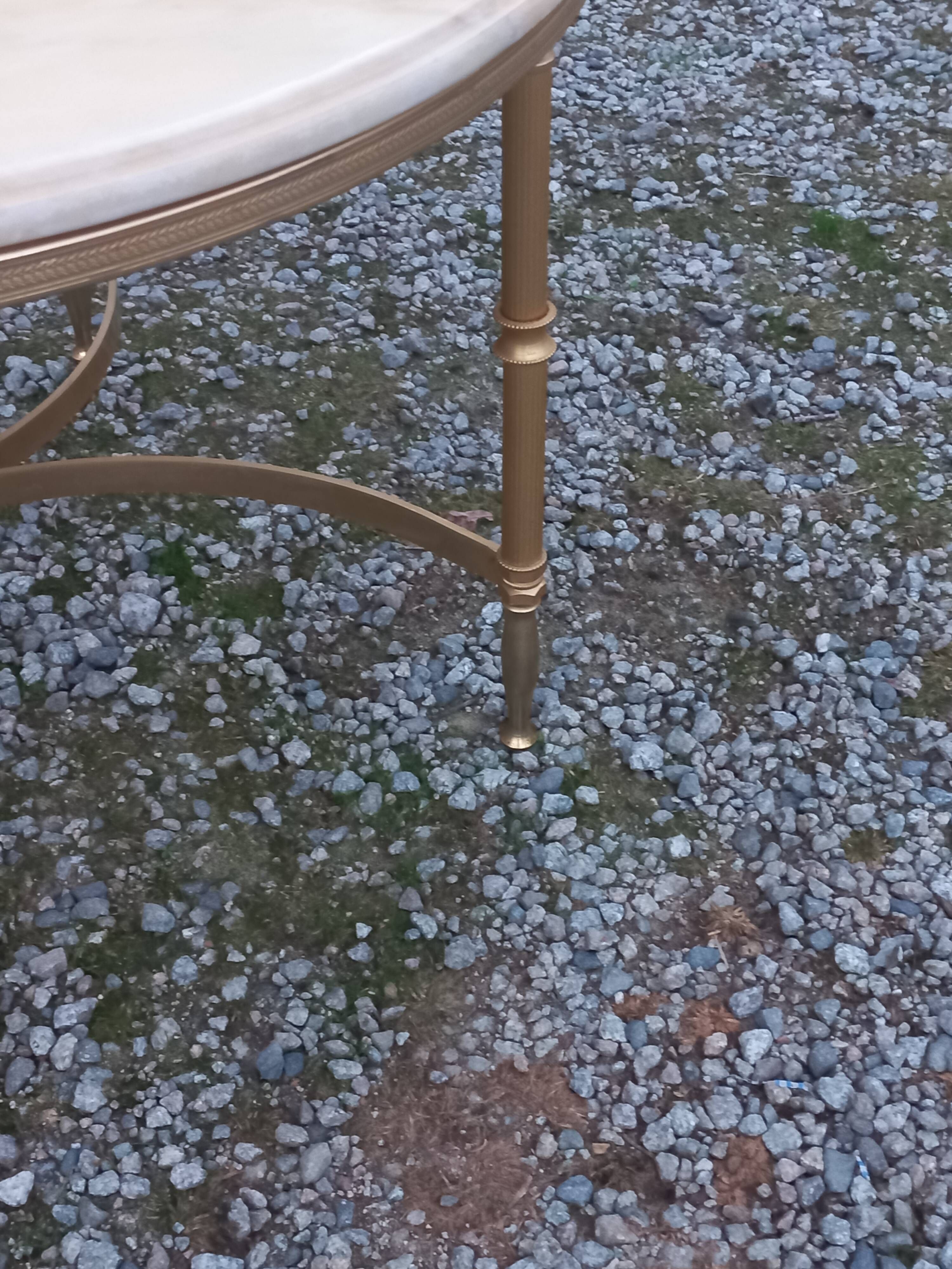 Round neoclassical coffee table with a marble top and golden metal base.