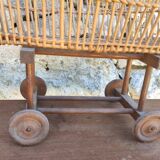 Old rattan cradle on wheels