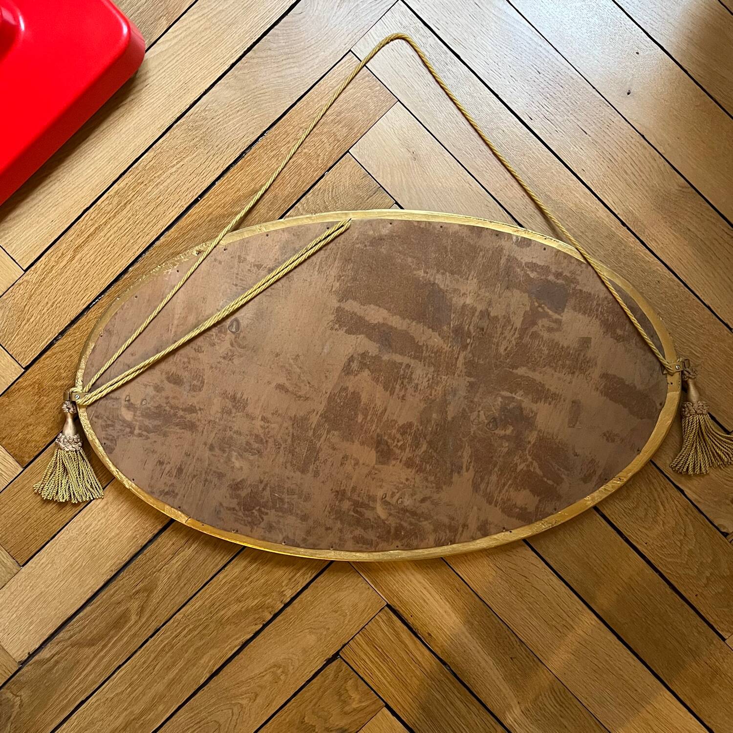 Antique oval beveled mirror adorned with tassels