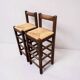 Set of 2 vintage wooden bar stools with woven straw seats.