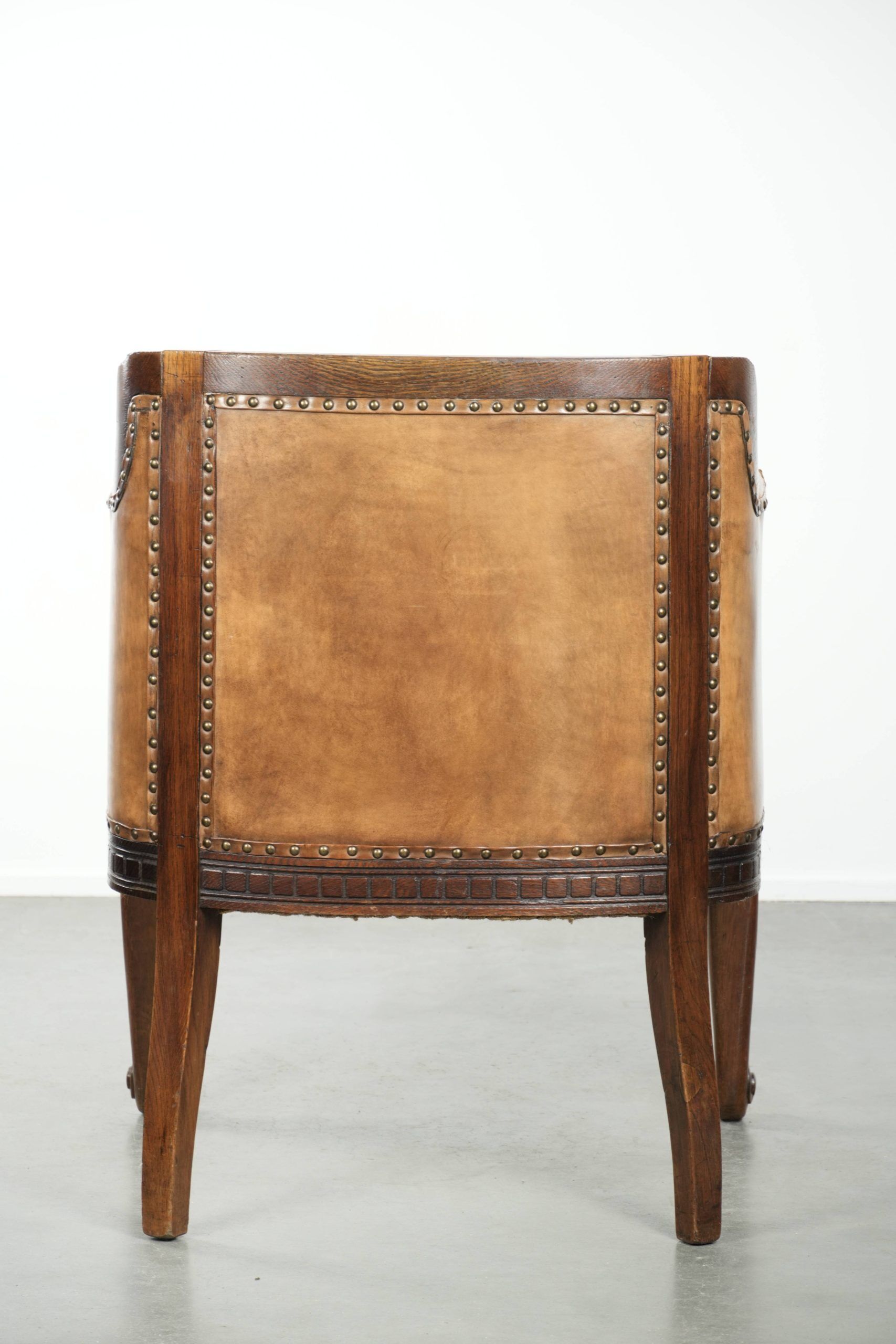Antique armchair made of sheepskin and wood with decorative nails