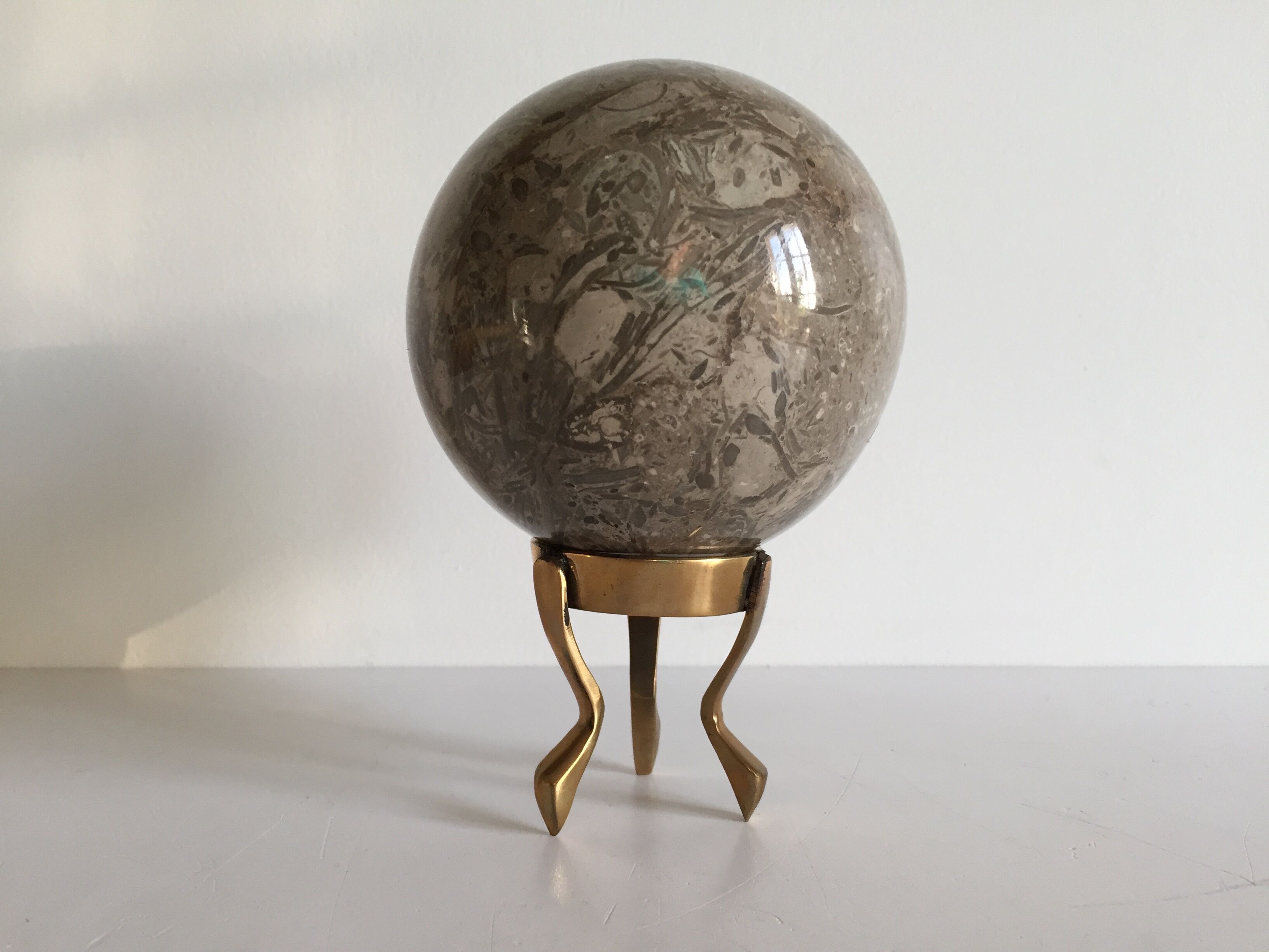 Marble ball paperweight on vintage brass