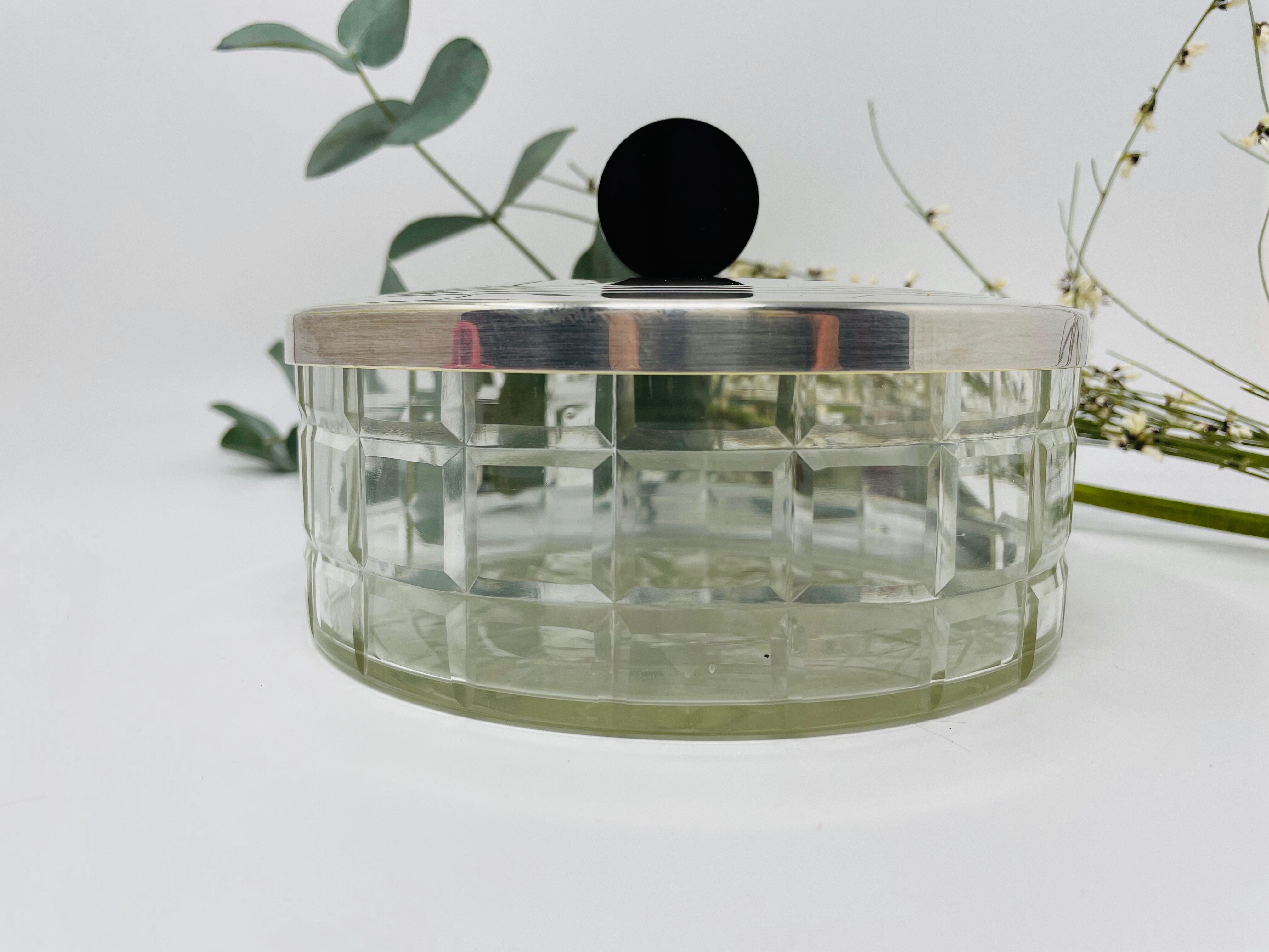 Vintage box made of chiseled glass and covered metal, taken in black Bakelite