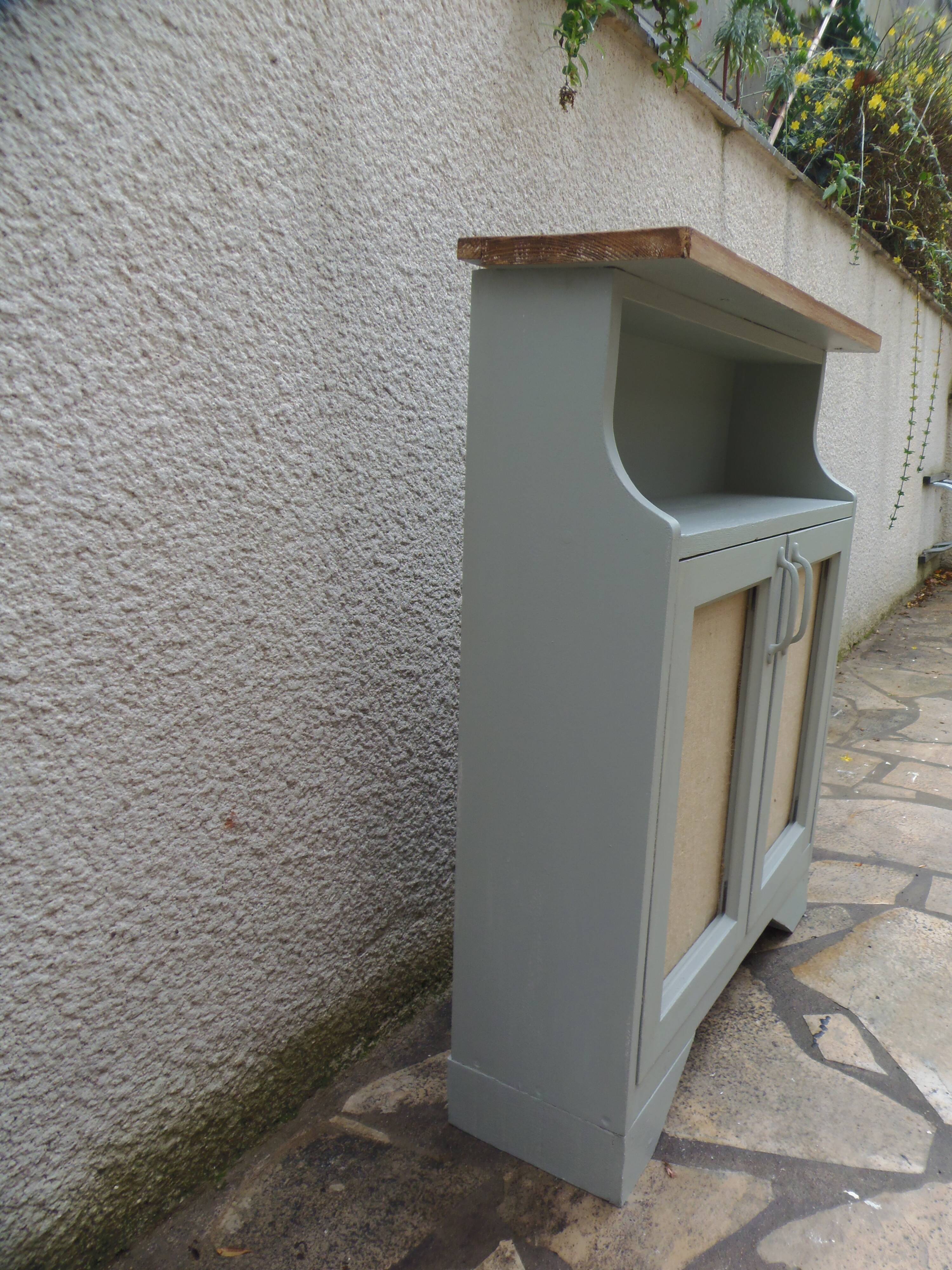 Small vintage green-grey piece of furniture, with 2 doors covered in burlap.