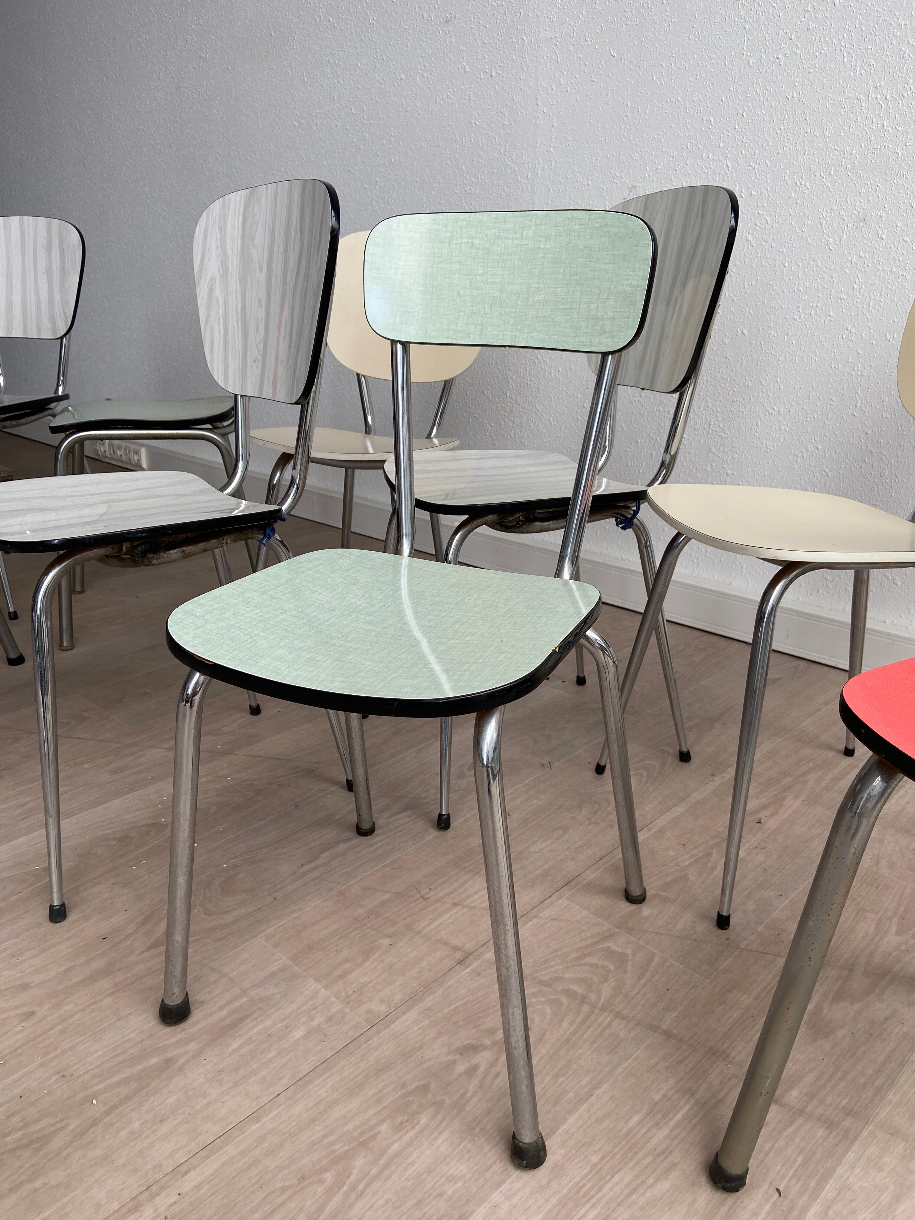 10 mismatched multicolored Formica chairs 60s
