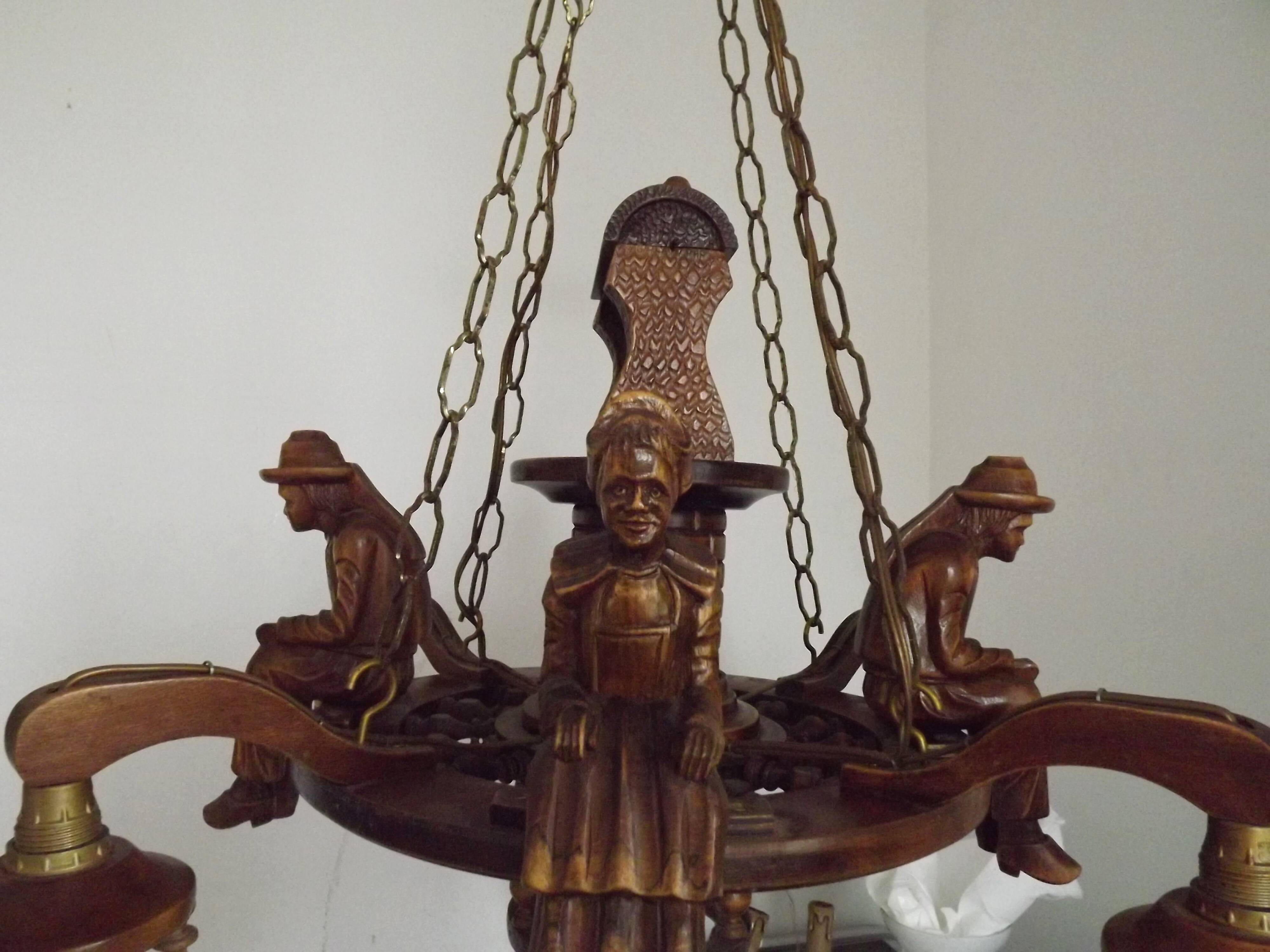 French vintage Breton chandelier with hand-carved figures, well, and lantern lights.