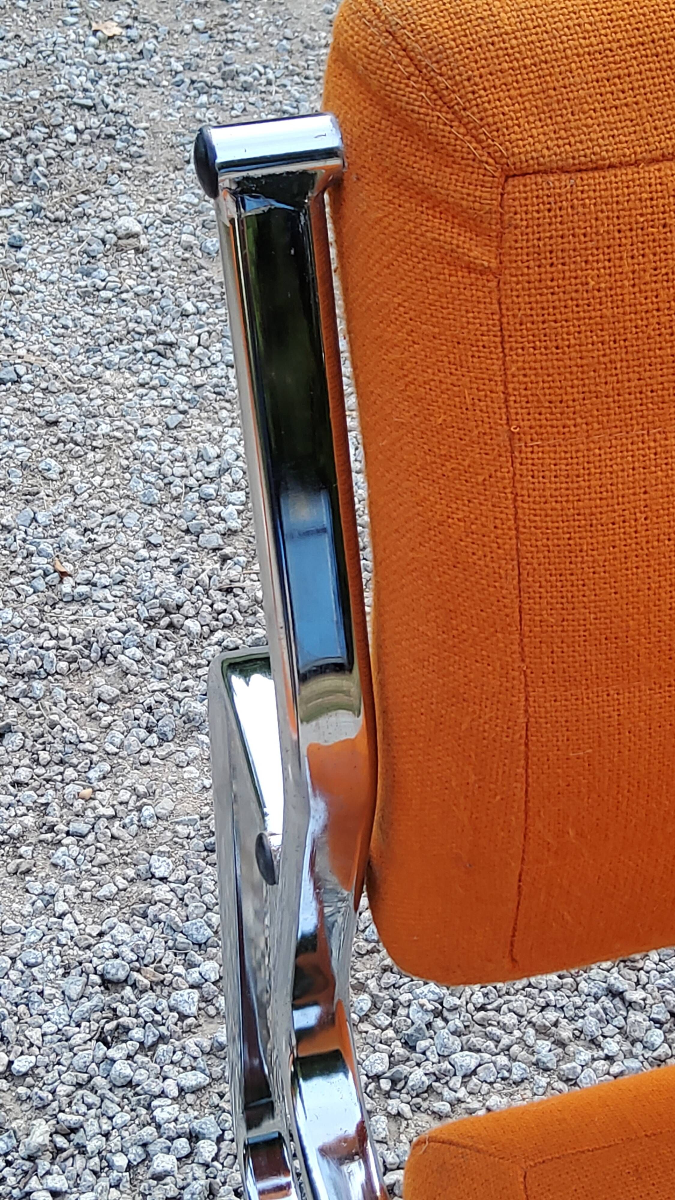 Pair of designer armchairs in orange fabrics and chrome tubes from the 70s