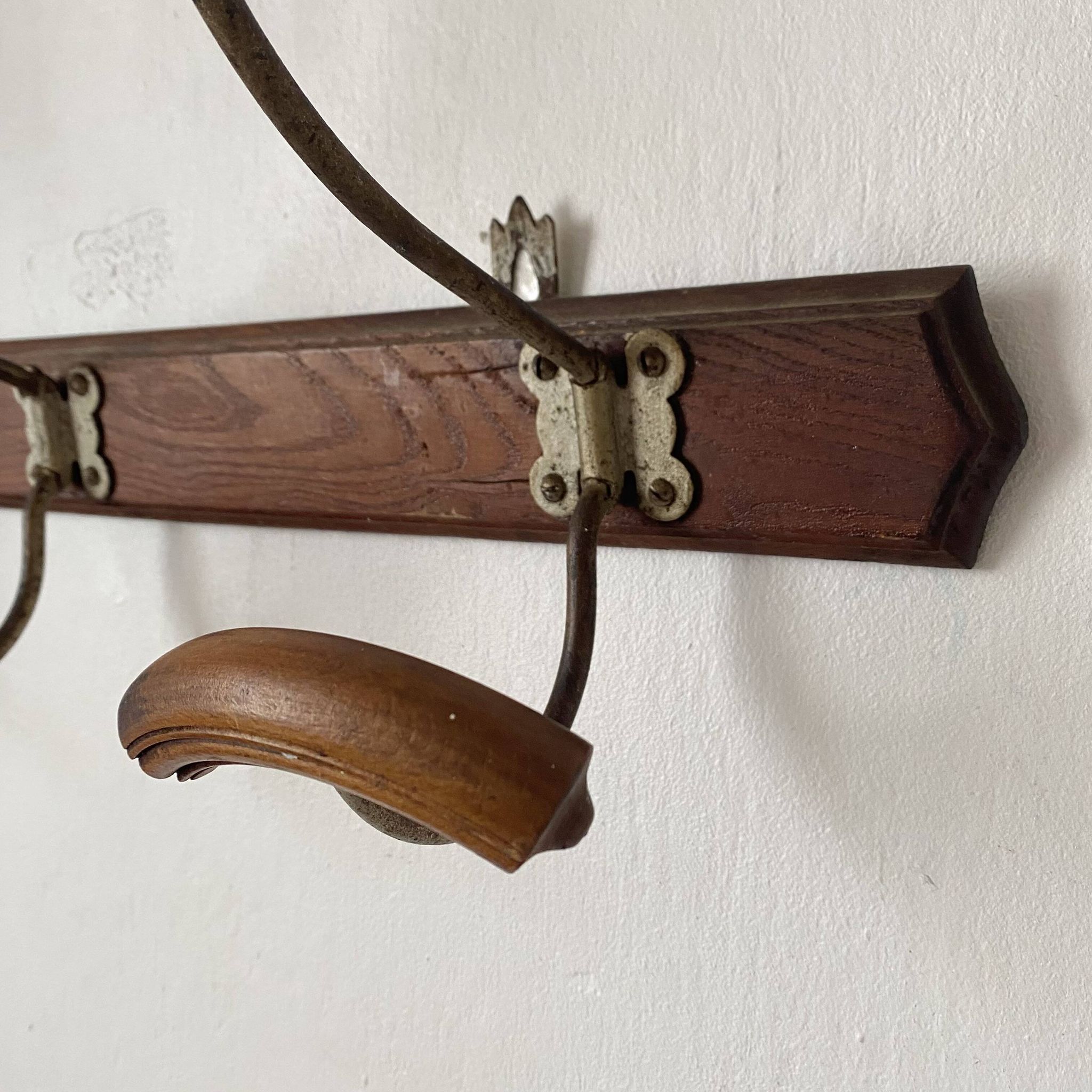 Old wooden and metal wall-mounted coat rack.