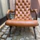 Chesterfield armchair in leather and carved solid wood