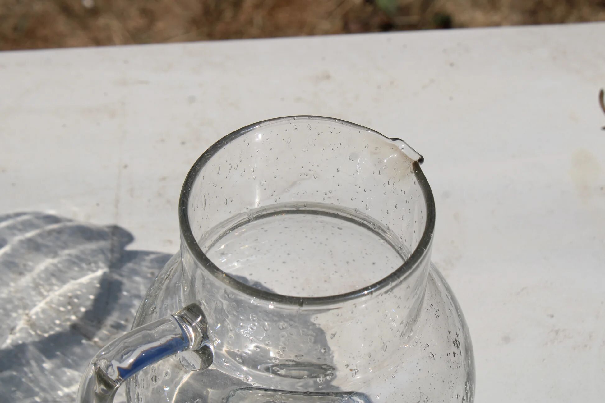 Vintage blown glass pitcher with bubbles, transparent.